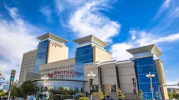 A modern hotel with a prominent glass facade and a rooftop structure.