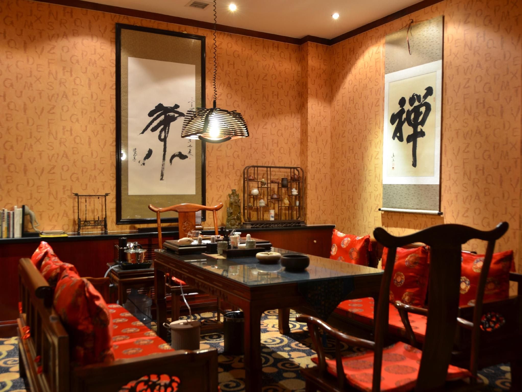 Quarto japonês tradicional com mesa baixa, cadeiras de madeira e almofadas vermelhas.