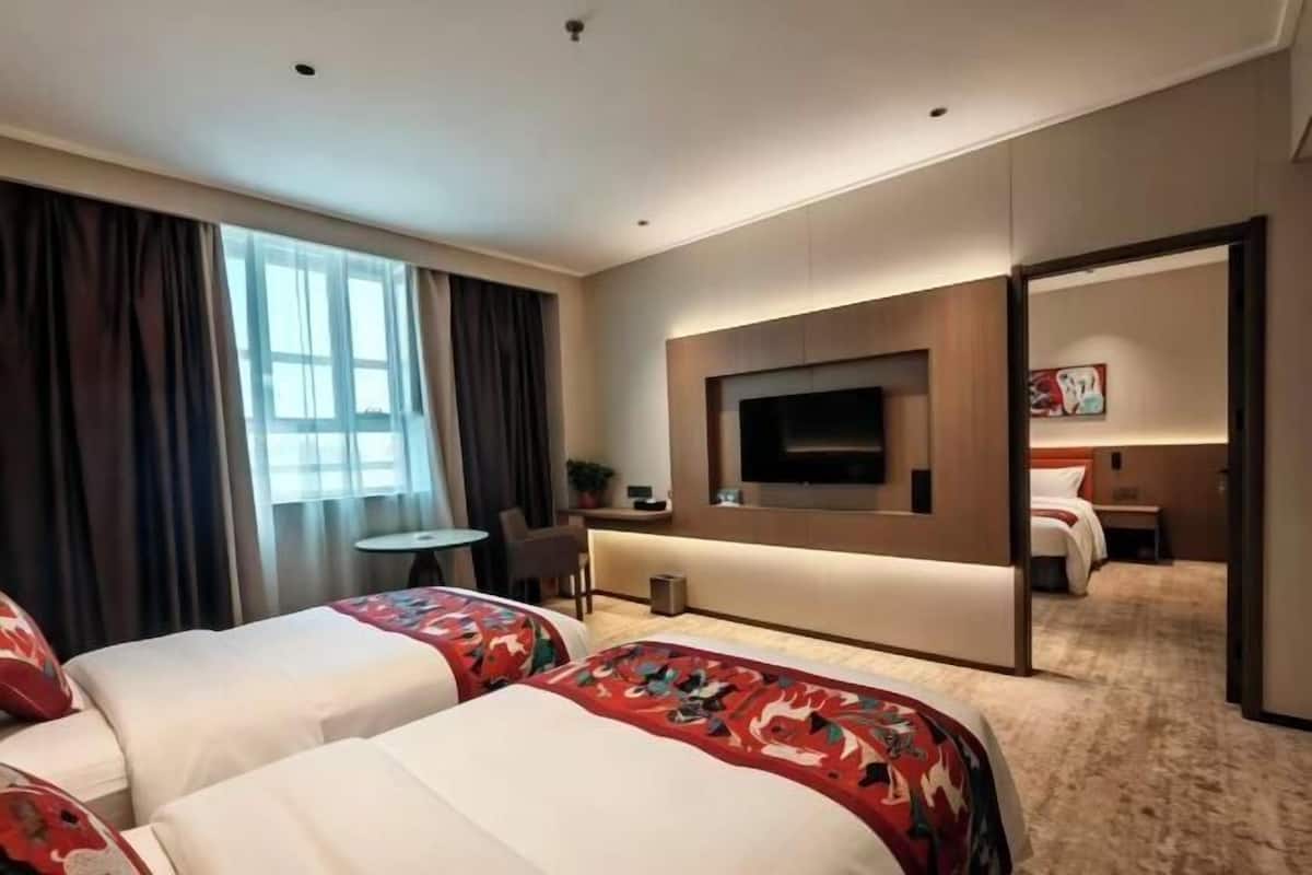 Ett hotellrum med två sängar, en TV, ett skrivbord och en stol.