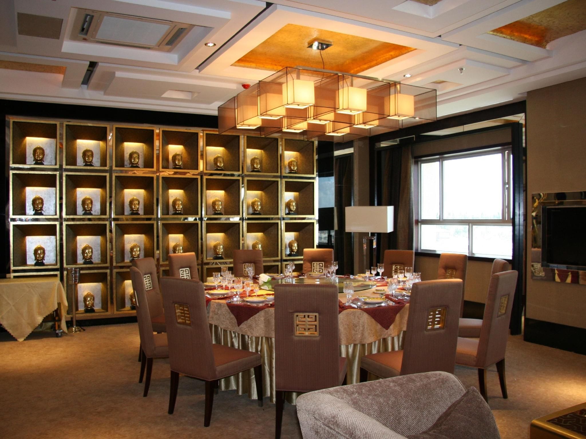 A dining area with a round table set for six, surrounded by chairs with a patterned design.