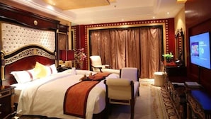 A hotel room with a large bed, a desk, a chair, and a television. - Grand Soluxe Hotel Dunhuang (Jiuquan)