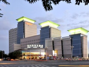 A hotel with a modern design, featuring a prominent entrance and a large sign.