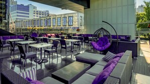 An outdoor seating area with tables and chairs, a hanging chair, and a sofa with cushions. - Mercure Kyiv Congress (Kyiv)