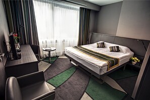 A modern hotel room with a large bed, a desk, and a chair. - Mercure Kyiv Congress (Kyiv)