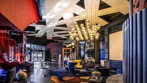 A modern hotel lobby with a central seating area, a reception desk, and a large chandelier. - Mercure Kyiv Congress (Kyiv)