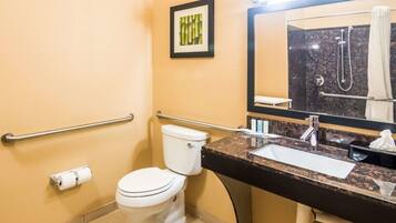 Een badkamer met toilet, wastafel, spiegel en een handgreep.