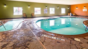 Una piscina interior con dos áreas diferenciadas, indicadores de profundidad marcados y suelo de baldosas de piedra.