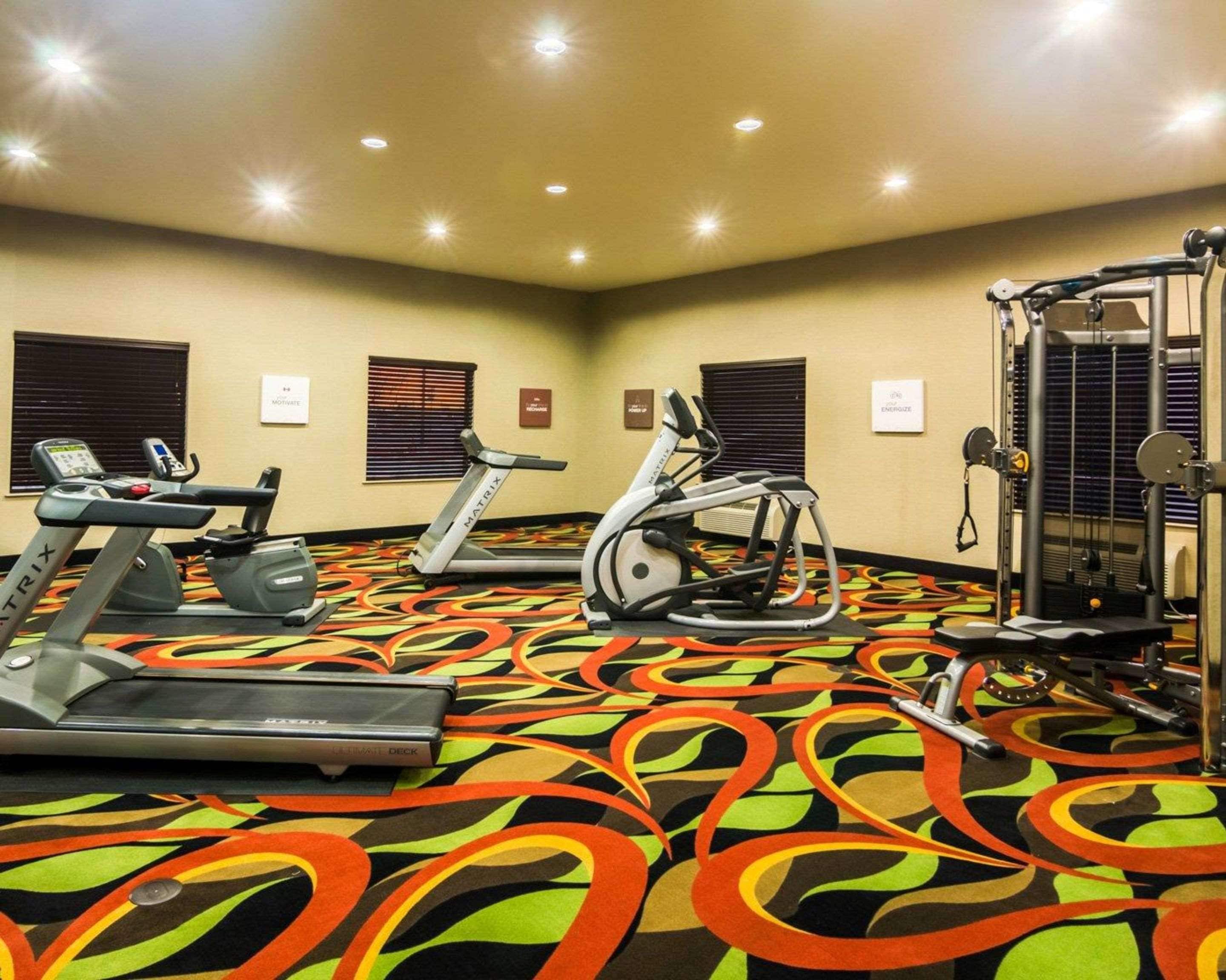 A gym with treadmills, stationary bikes, and a weight machine.