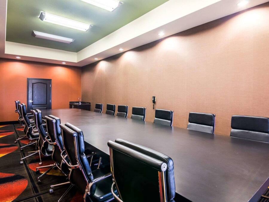 A conference room with a long table, multiple chairs, and a door.