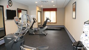 Un centre de remise en forme équipé de tapis de course, de vélos elliptiques et d’un vélo d’appartement.