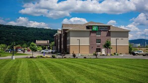 A Holiday Inn Express building with a parking lot and a green lawn in front. - Holiday Inn Express Bradford by IHG (Bradford)