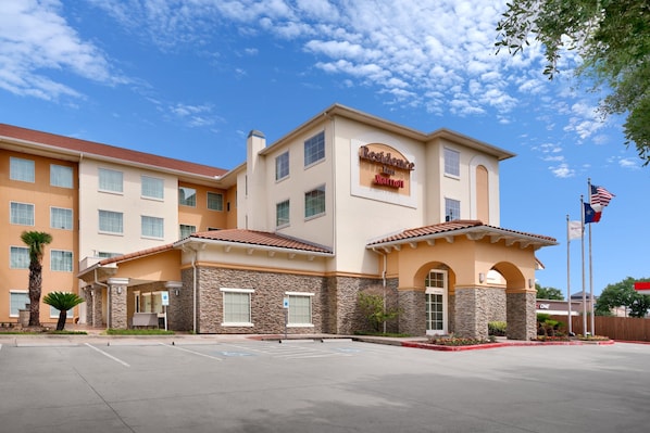 A hotel with a sign reading "Residence Inn by Marriott," featuring a two-story building with a tiled roof and stone accents. - Residence Inn Houston I-10 West/Park Row (Houston)