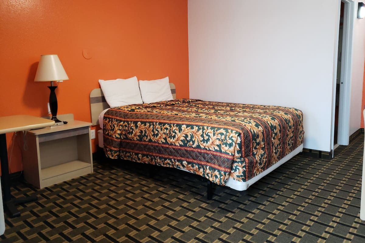 Ein Hotelzimmer mit einem Bett, einem Schreibtisch und einer Lampe.