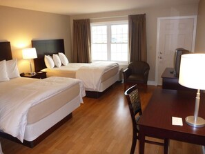 Comfortable room with two single beds, a seating area, and a large window.
