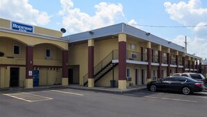 Ein Motel mit einem Schild, auf dem "Rodeway Inn" steht, und einem Parkplatz mit Autos.
