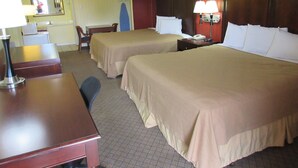 Ein Hotelzimmer mit zwei Betten, einem Schreibtisch, einem Stuhl, einem Telefon und einem Spiegel.