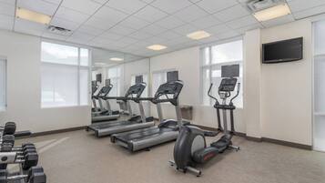 Een sportschool met loopbanden, elliptische trainers en gewichten.