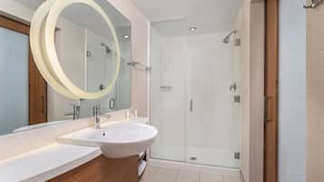 Une salle de bain moderne avec un grand lavabo, un miroir et une douche à parois de verre.