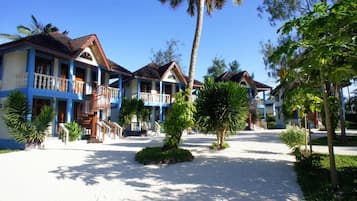 Un resort con varias edificaciones de dos pisos, cada una con un balcón y una escalera que conduce a la entrada.