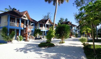Un resort con varias edificaciones de dos pisos, cada una con un balcón y una escalera que conduce a la entrada.