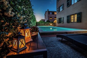 Una piscina al aire libre de temporada, sillones reclinables de piscina