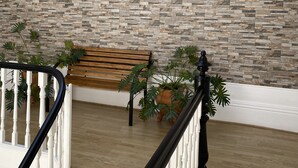 A staircase with a stone wall, a wooden bench, and a potted plant. - GuestHouse do Marquês (Porto)
