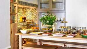 A buffet setup with various food items and a plant centerpiece. - Noble House Essence Évora - by Unlock Hotels (Évora)