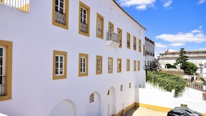 A white building with yellow window frames and a balcony. - Noble House Essence Évora - by Unlock Hotels (Évora)