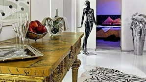 Ein Zimmer mit einem Marmortisch, einem zebraartigen Teppich und verschiedenen Skulpturen.