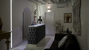 Ein modernes Wohnzimmer mit einem dunklen Sofa, einem gepolsterten Hocker und einem minimalistischen Design.