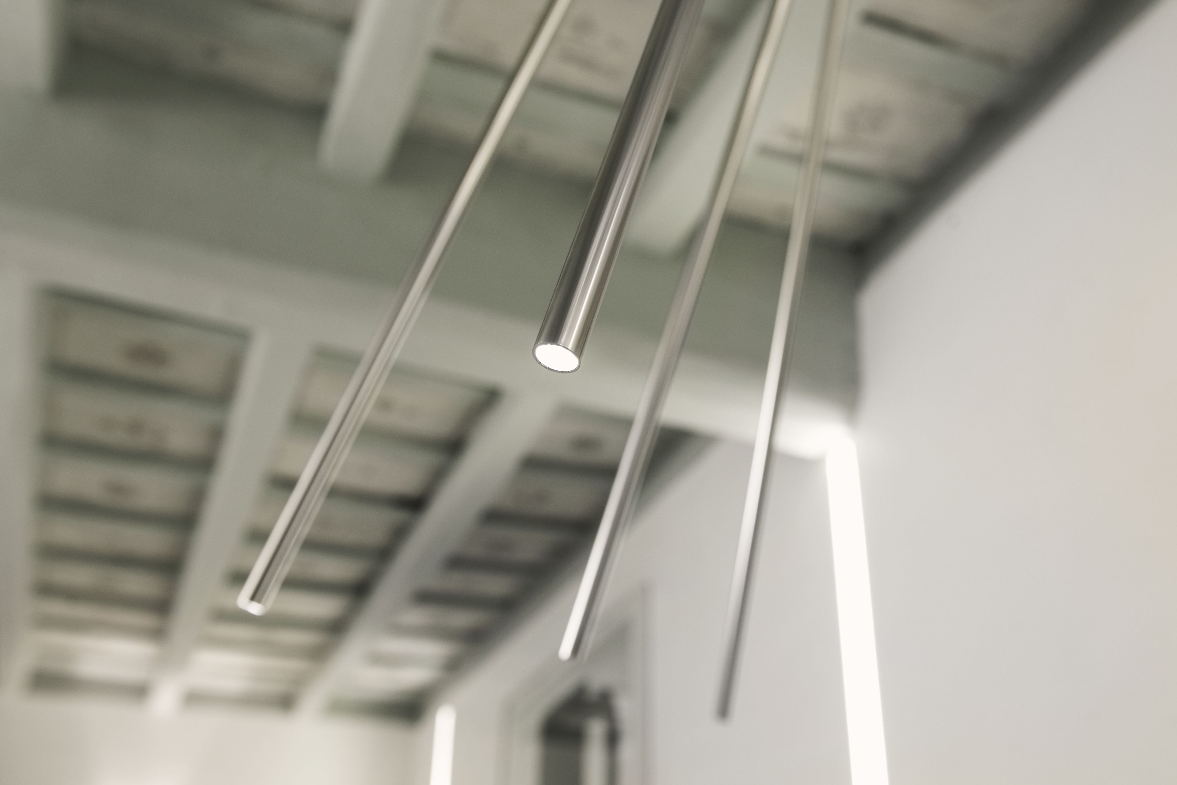 A modern interior with exposed ceiling beams and hanging light fixtures.