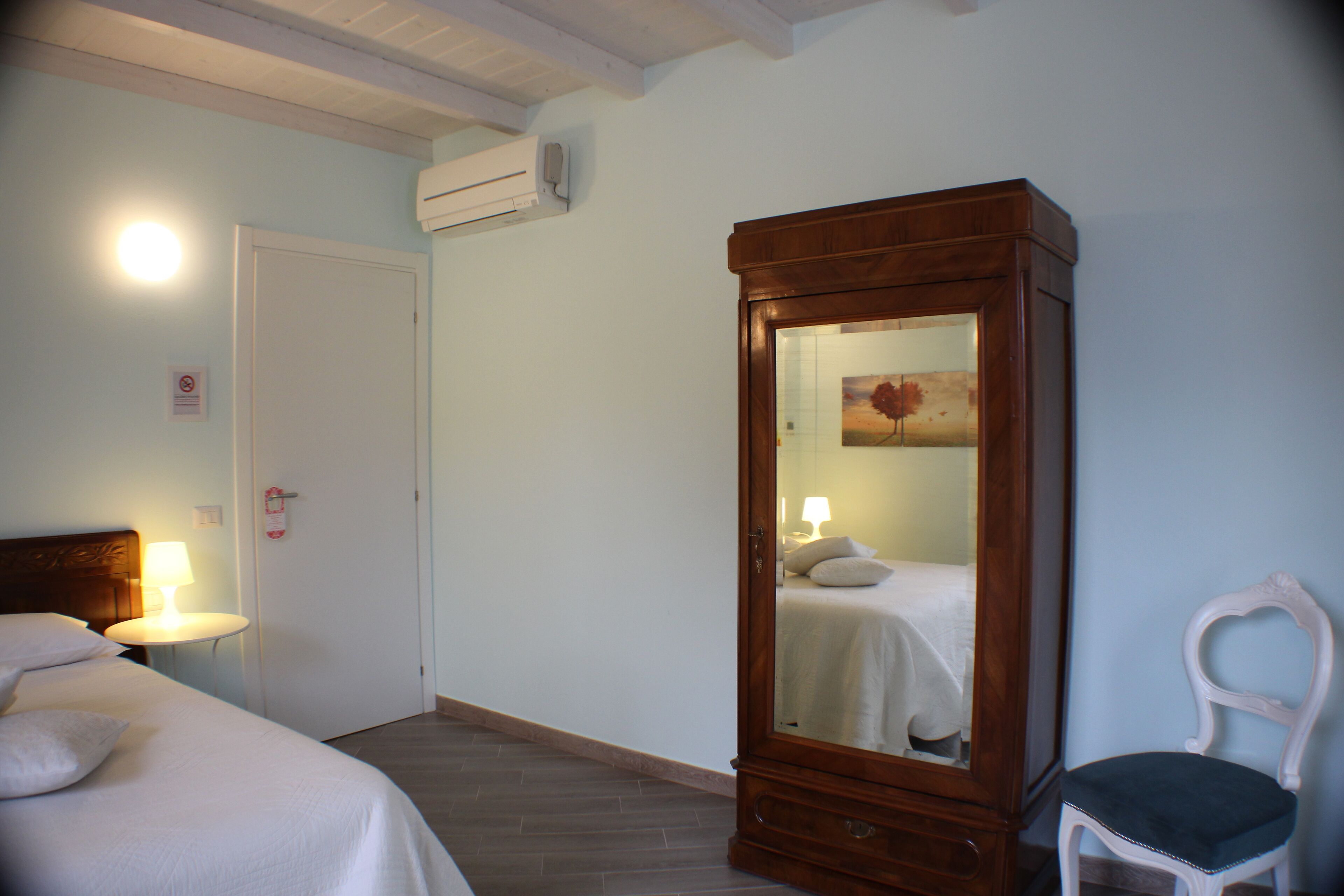 A hotel room with a bed, a nightstand, a dresser, and a chair.