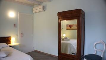 A hotel room with a bed, a nightstand, a dresser, and a chair.