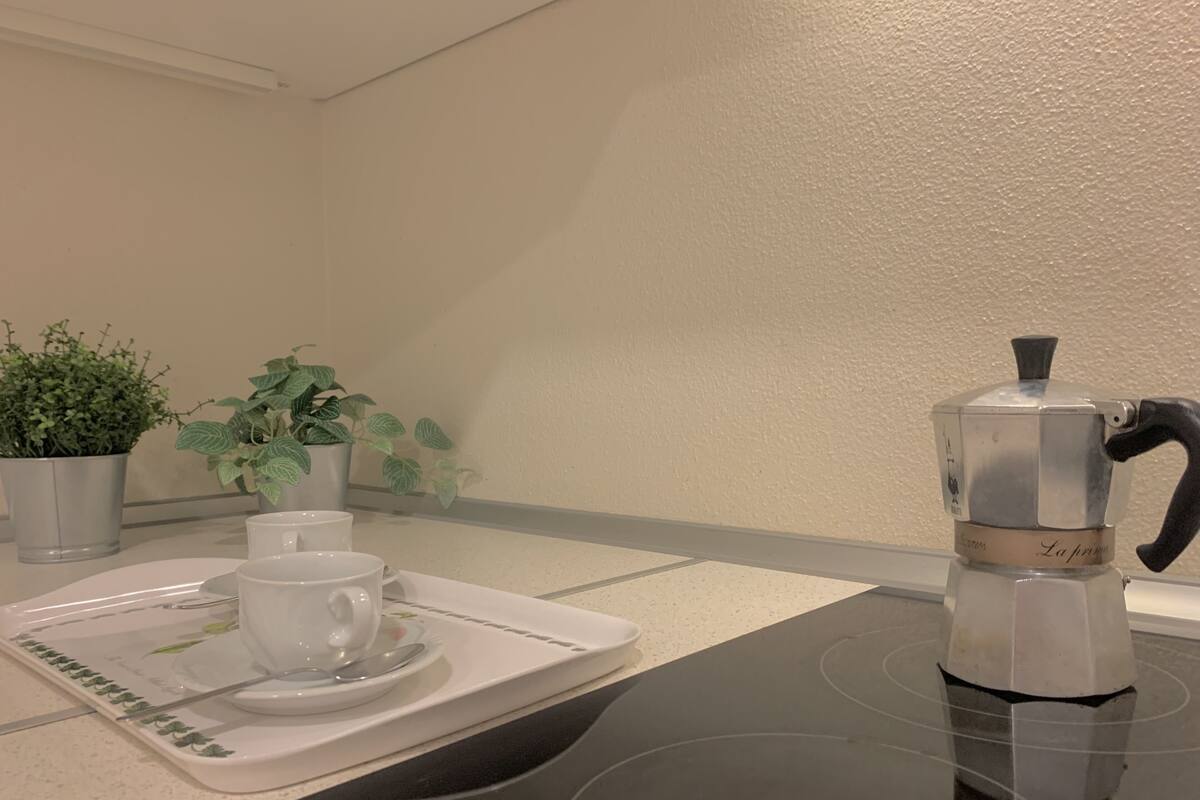 Une table avec une machine à café, deux tasses et un plateau.