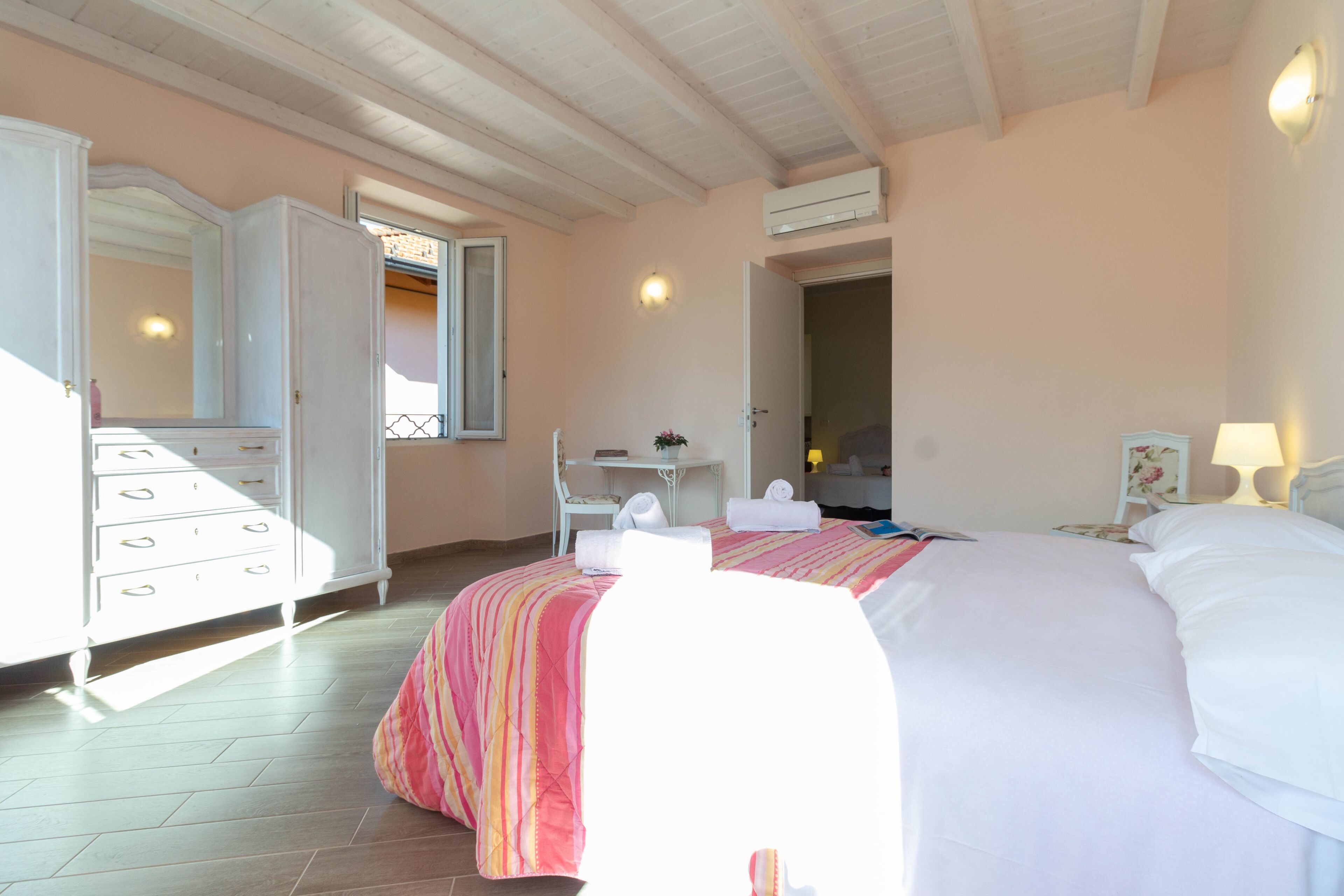 Un dormitorio con cama, tocador, escritorio y silla.