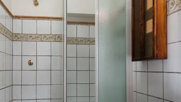Un baño con inodoro, bidé y cabina de ducha.