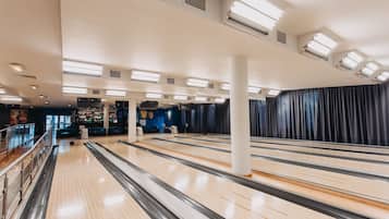 A bowling alley with multiple lanes, a bar area, and a seating section.
