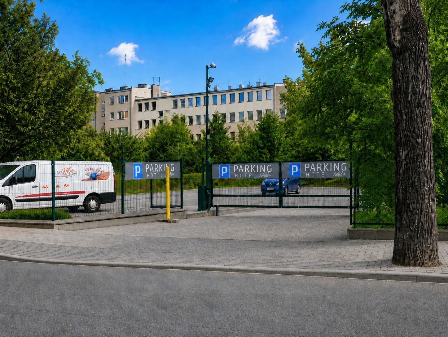 Een omheind parkeergebied met meerdere borden die hotelparkeren aangeven.