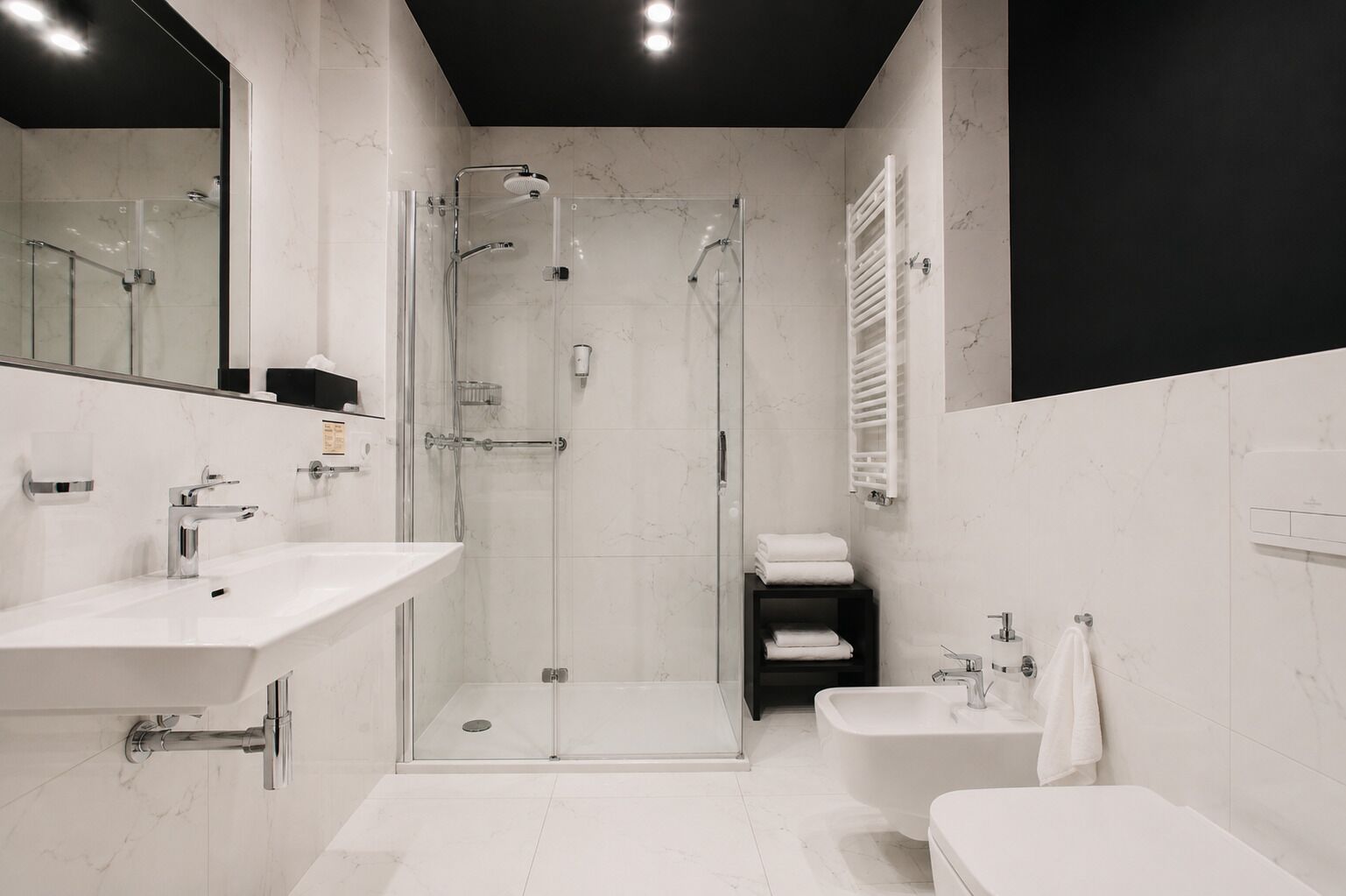 A modern bathroom with a glass-enclosed shower, a vanity with a sink, and a bathtub.