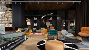 A modern living room with a fireplace, various seating options, and a large window. - Hotel Euro (Pardubice)