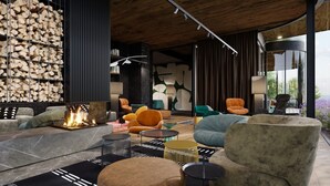 A modern lounge area with a fireplace, comfortable seating, and a view of the outdoors. - Hotel Euro (Pardubice)