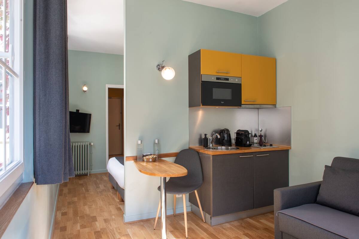 A compact living space with a kitchenette, a dining area, and a seating area.