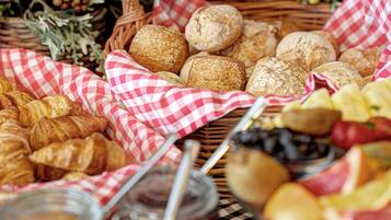 A variety of baked goods, including bread and pastries, arranged on a checkered cloth.
