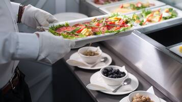En buffet med forskellige retter samt skåle med oliven og blåbær.