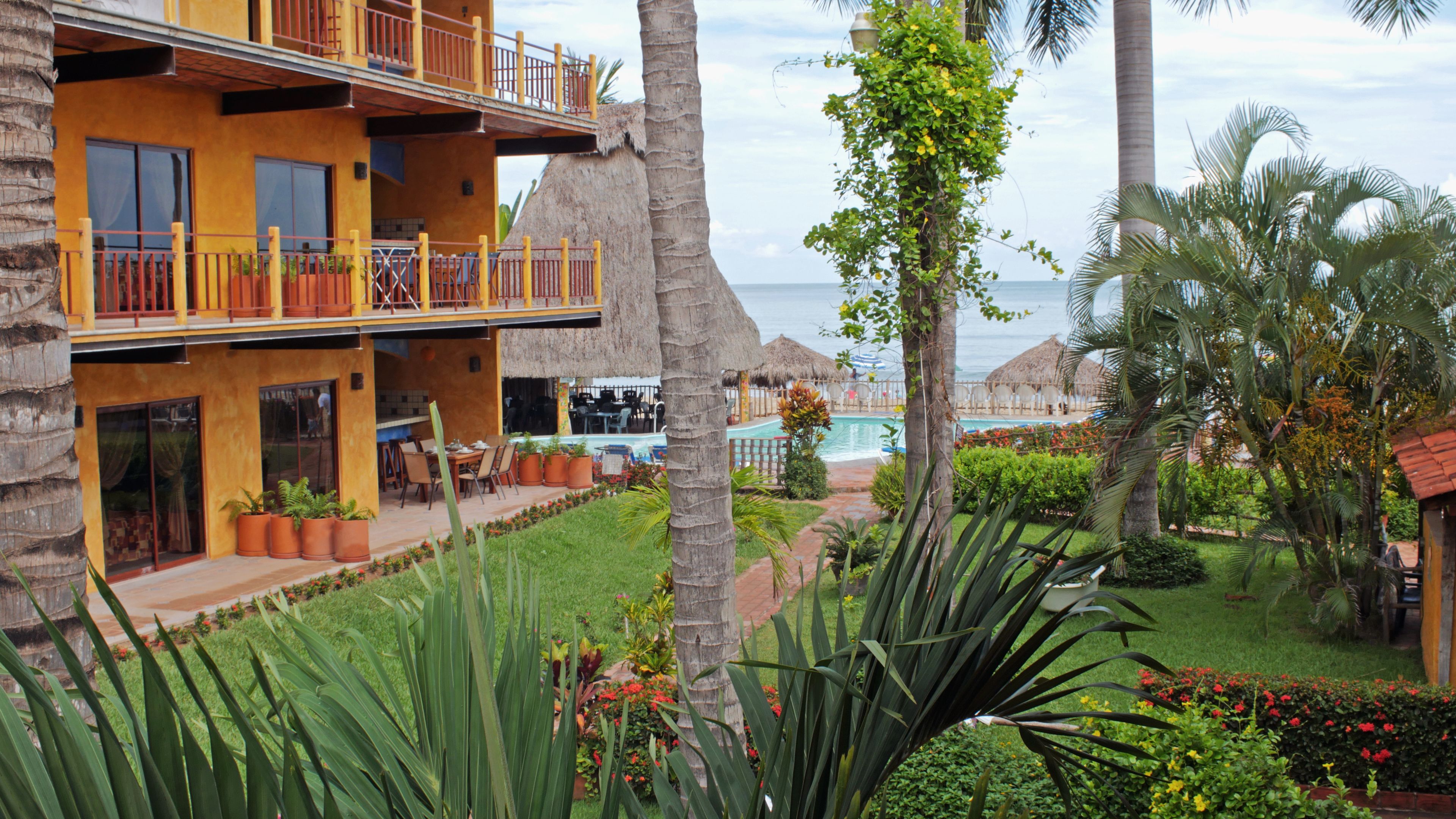 Un resort con piscina, mobiliario exterior y vista al océano.