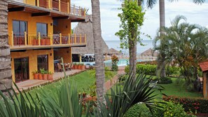 Un resort con piscina, mobiliario exterior y vista al océano.