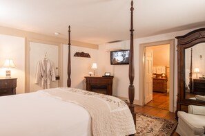 A bedroom with a four-poster bed, a television mounted on the wall, and a mirror with a wooden frame. - Caldwell House Bed & Breakfast (Salisbury Mills)