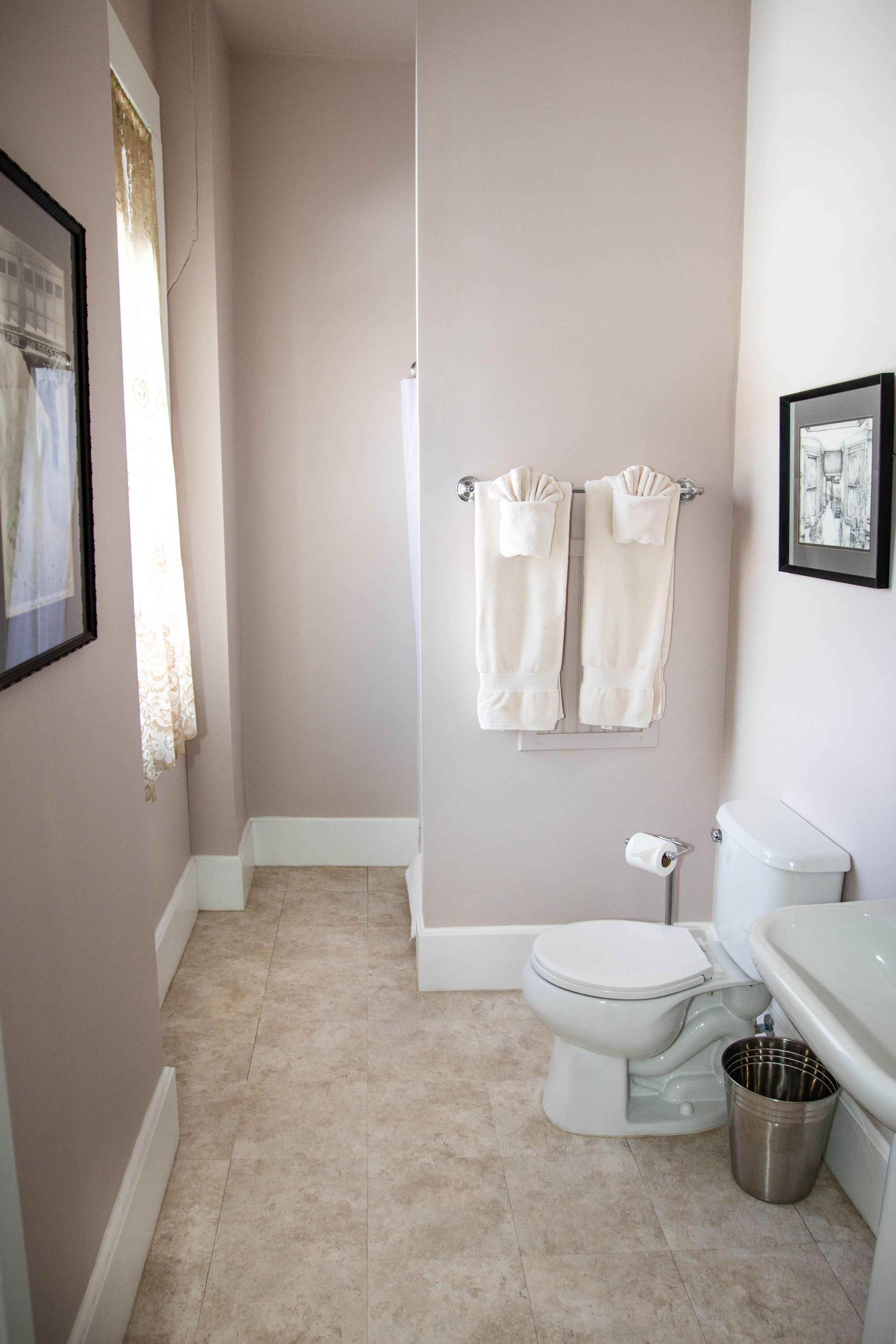 A bathroom with a toilet, a sink, and a trash can.