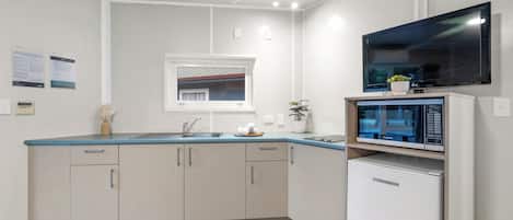 Una cocina moderna con microondas integrado, un fregadero y una ventana sobre la encimera.