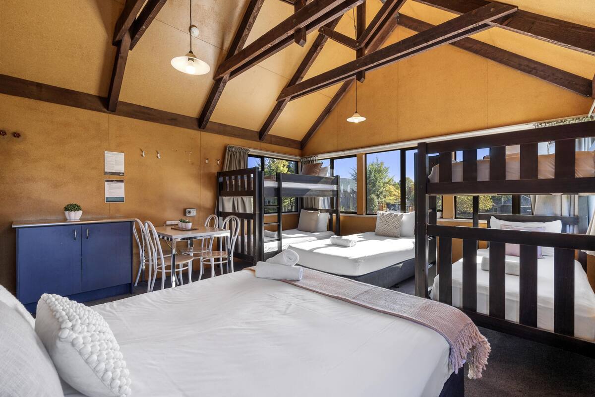 Un dormitorio con una cama grande, un escritorio y un balcón.